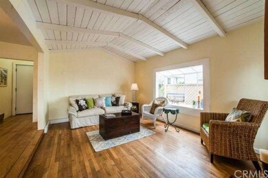 Living room w/wood floors, open beam ceiling, bay 