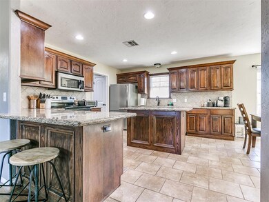 Kitchen featuring light stone counters, light tile