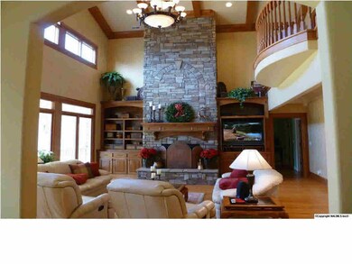 This view of the soaring ceiling in the Living Room shows the exposed beams, the gorgeous stone fireplace and the Balcony to the right.