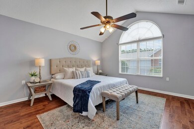 Bedroom featuring ceiling fan, a textured ceiling, dark hardwood / wood-style flooring, and vaulted ceiling