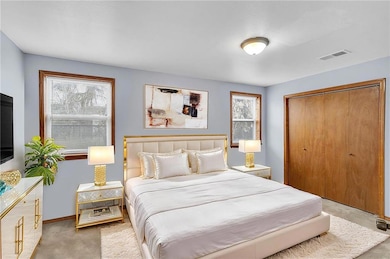 Downstairs Bedroom has two wood trimmed windows and a large closet. Staged.