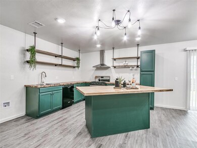 Kitchen with wall chimney exhaust hood, light hard