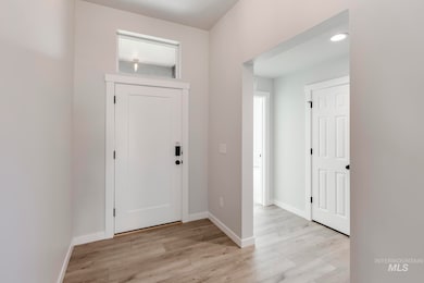 Foyer featuring light wood-style floors and baseboards