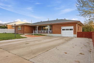 Ranch-style house featuring concrete driveway, brick siding, a shingled roof, and an attached garage
