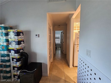 Hall with light tile patterned floors and baseboar