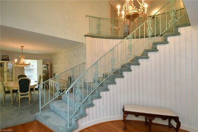 Grand foyer with curved staircase opens to Dining 