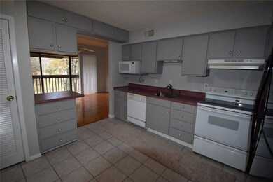 This photo shows a kitchen with gray cabinets and