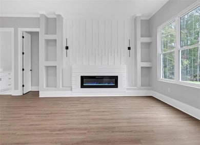 Unfurnished living room featuring baseboards, orna