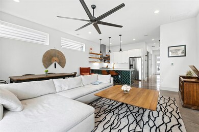 Living area with visible vents, a ceiling fan, an