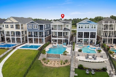 Back of property with a balcony, a pool with connected hot tub, stairs, and a residential view
