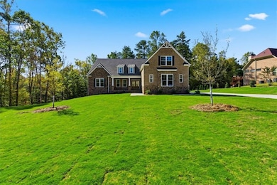 Craftsman-style home with a front yard, a porch, and brick siding