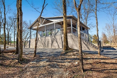 View of side of property featuring gravel driveway