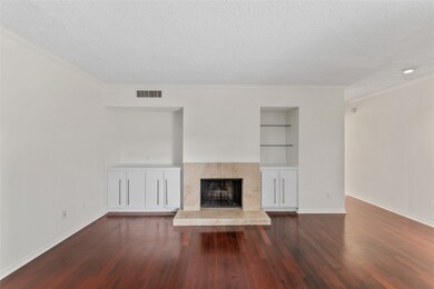 Wood burning fireplace and built in shelving/cabinets on either side of fireplace