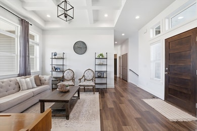 Formal living room featuring plenty of natural light, recessed lighting, beam ceiling, coffered ceiling, and dark wood-type flooring