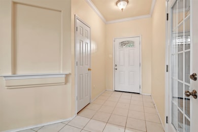 Front entry of home features tile flooring, crown