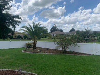 Back yard that is fenced in with Palm Tree and Lan