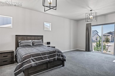 Bedroom with a chandelier, carpet flooring, multiple windows, and access to exterior
