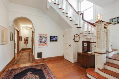 Foyer with intricate stairwell details, archway wi