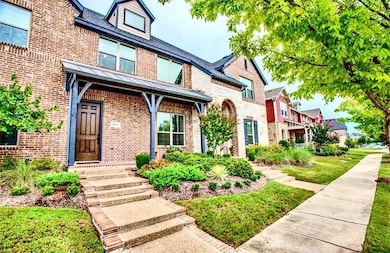 View of front facade featuring brick siding, covered porch, a standing seam roof, and a metal roof