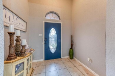 Tiled entry with an accent colored door & space for a welcome table.