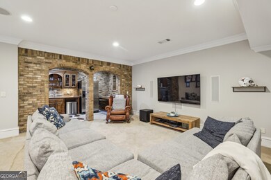 The Fully Finished Daylight Terrace Level is made for Entertaining with a Large Living Space, Built-In Sound System, Wet Bar framed by Brick Archways, and Direct Access to a Charming Outdoor Patio.