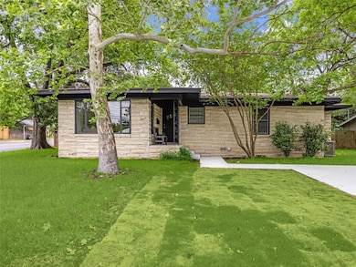 Mid-century inspired home with a front yard and stone siding