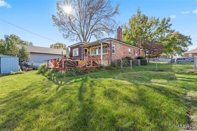 Back of property featuring a chimney, a fenced backyard, a deck, and brick siding