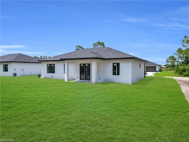 Back of property featuring stucco siding and a lawn