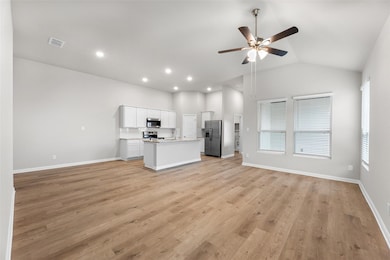 Unfurnished living room featuring a ceiling fan, 