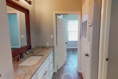 Bathroom with vanity, a textured wall, and wood f