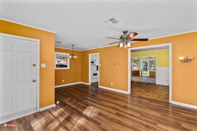 Unfurnished living room with crown molding, dark w