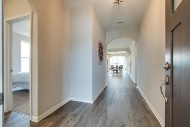 Tasteful, inviting arched entry foyer with vast hallway to living area and upgraded front door with view level glass on top