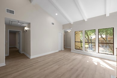 Unfurnished living room with high vaulted ceiling