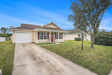 Ranch-style home with a shingled roof, driveway, covered porch, and a front yard