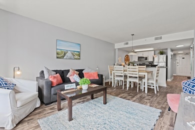 Living room with visible vents, baseboards, and wo