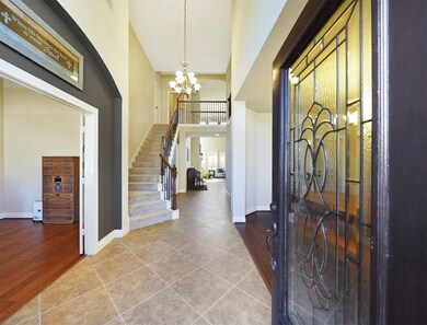 Stunning front foyer, featuring an 18-ft ceiling, ceramic tile flooring, incredible natural light, and gorgeous iron stair parts.