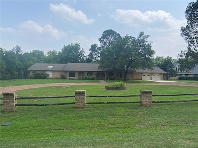 Ranch-style house with a front yard and a garage