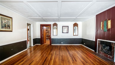 Unfurnished living room with dark wood-style floors, a fireplace, and coffered ceiling