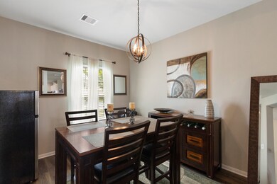 The formal dining room also boasts a custom industrial-style light fixture, and large window with 2