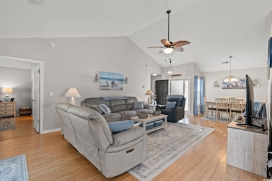 Living room featuring vaulted ceiling, baseboards,