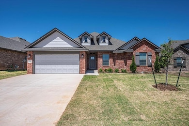 View of front of property with brick siding, a garage, driveway, a front yard, and a shingled roof