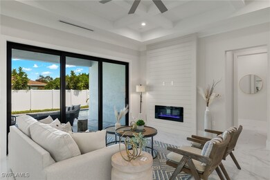 Living room with ceiling fan, a fireplace, coffere