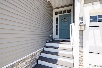 View of exterior entry featuring stone accents