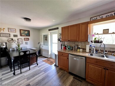 Kitchen featuring sink, dishwasher, tasteful backsplash, and light wood-type flooring