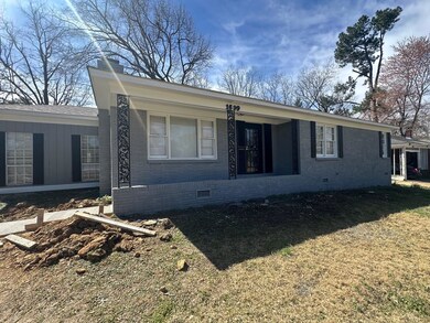 View of front of house with a front yard, brick si