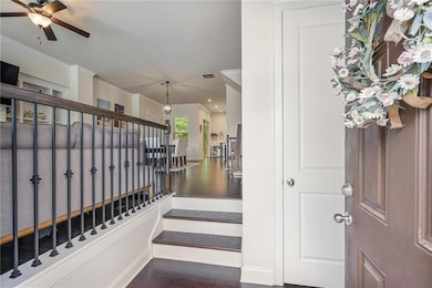 Stairway featuring wood finished floors, ornamental molding, ceiling fan, and recessed lighting