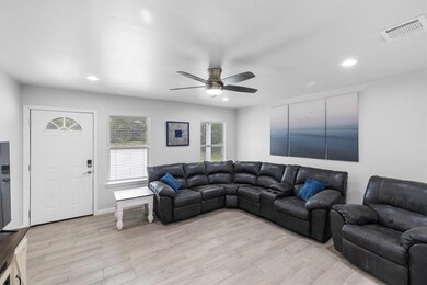 Living room featuring light wood-type flooring, ceiling fan, and recessed lighting
