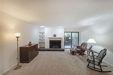 Living area featuring gas log fireplace and sliding glass doors to patio