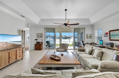 Tiled living room featuring a tray ceiling, plenty