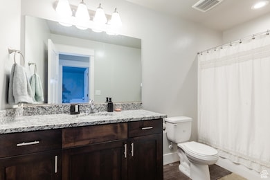 Full bathroom with vanity and wood finished floors